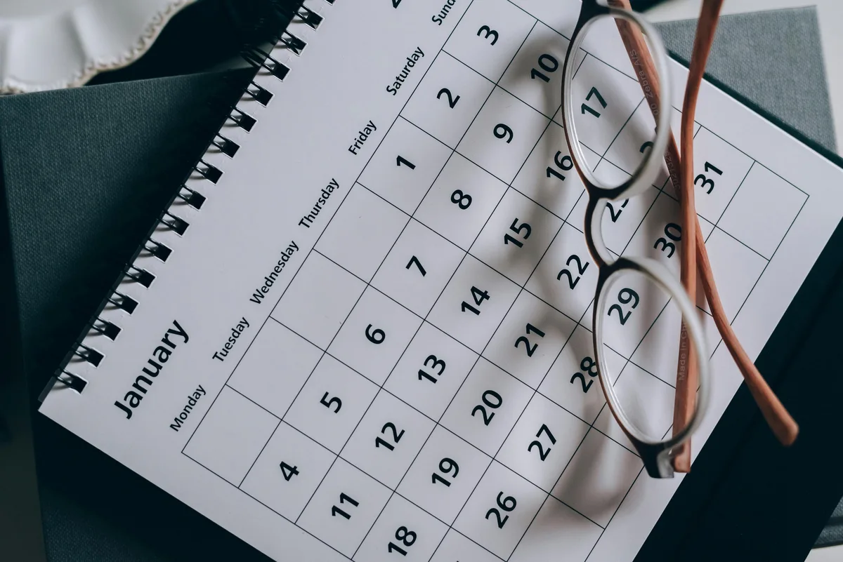 Agenda papier ouvert avec une paire de lunettes posée dessus.