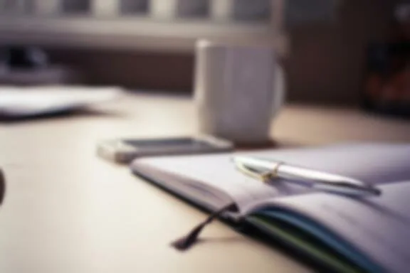 Bureau avec ordinateur portable et bloc-notes, gestion des rendez-vous à distance.