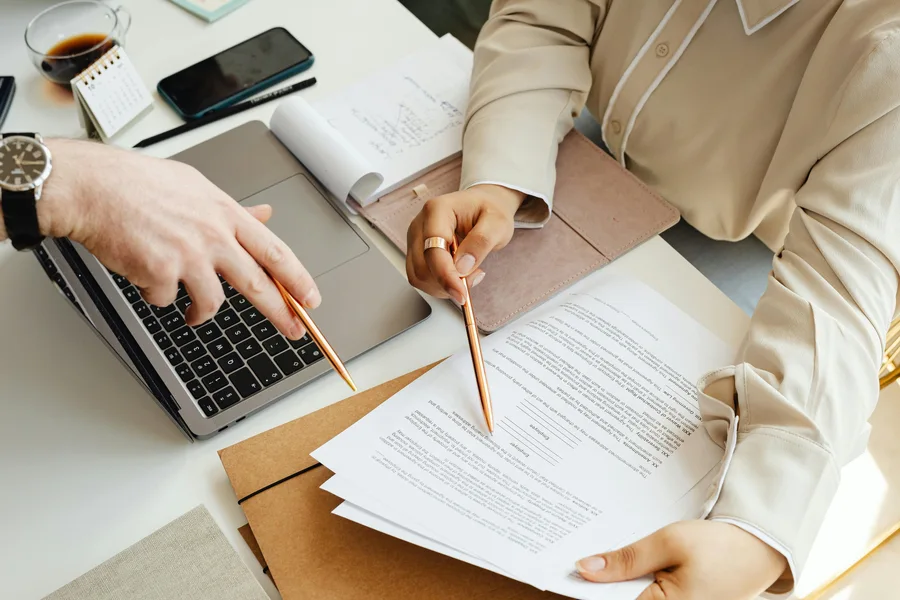 Bureau administratif : classeurs, calculatrice et documents en cours de traitement.