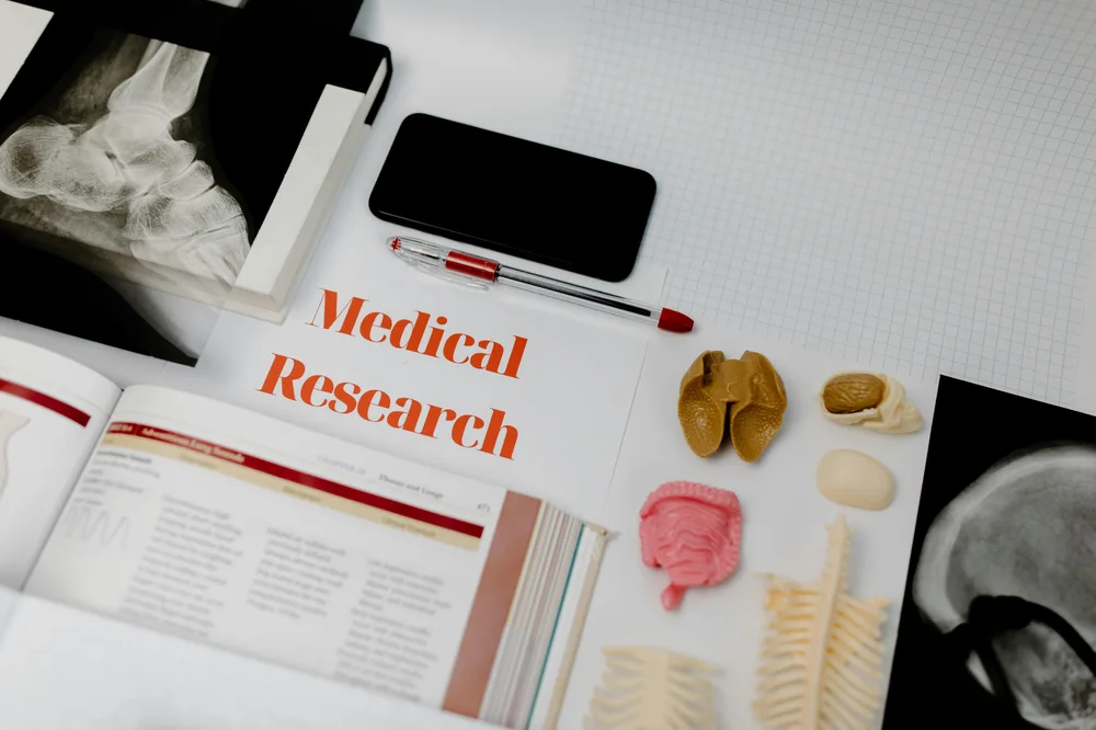 Documents médicaux et petit matériel de bureau sur un plan de travail clair.