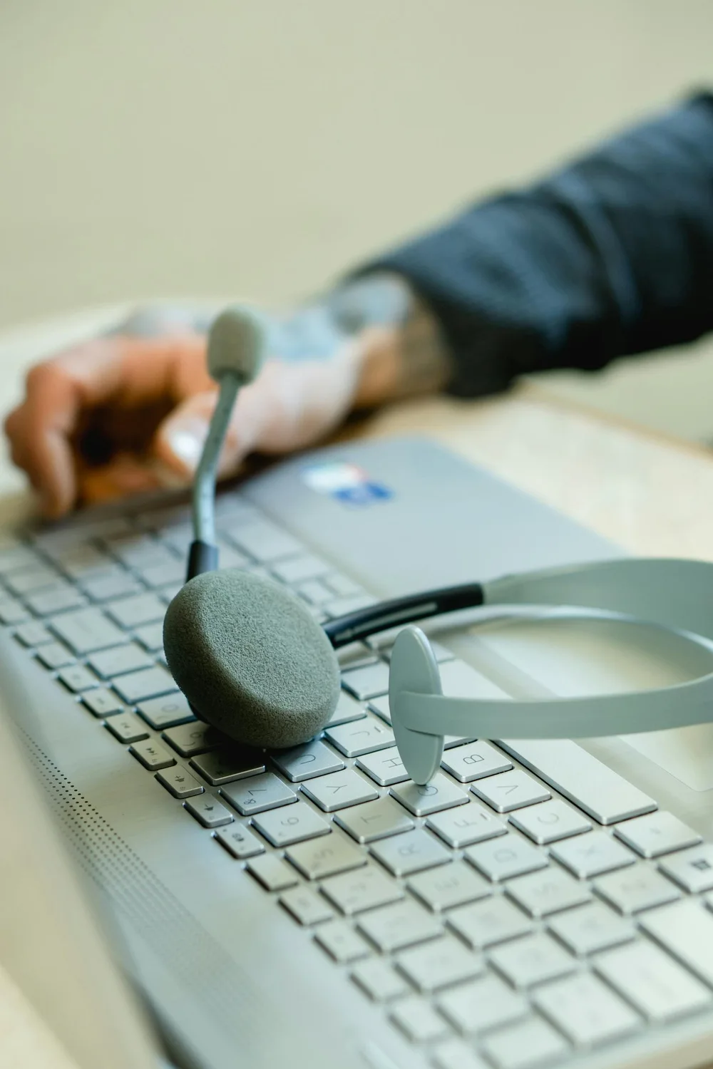 Mains sur un clavier, casque de télésecrétariat posé à côté.